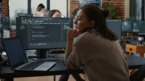 Junior developer putting laptop with source code on senior dev desk asking for opinion